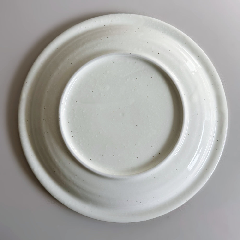 Raised rim dinner plate in cream white glaze. Fuchisabi Kohiki Plate made in Gifu prefecture, Japan. Mino Ware. Available at Toka Ceramics.