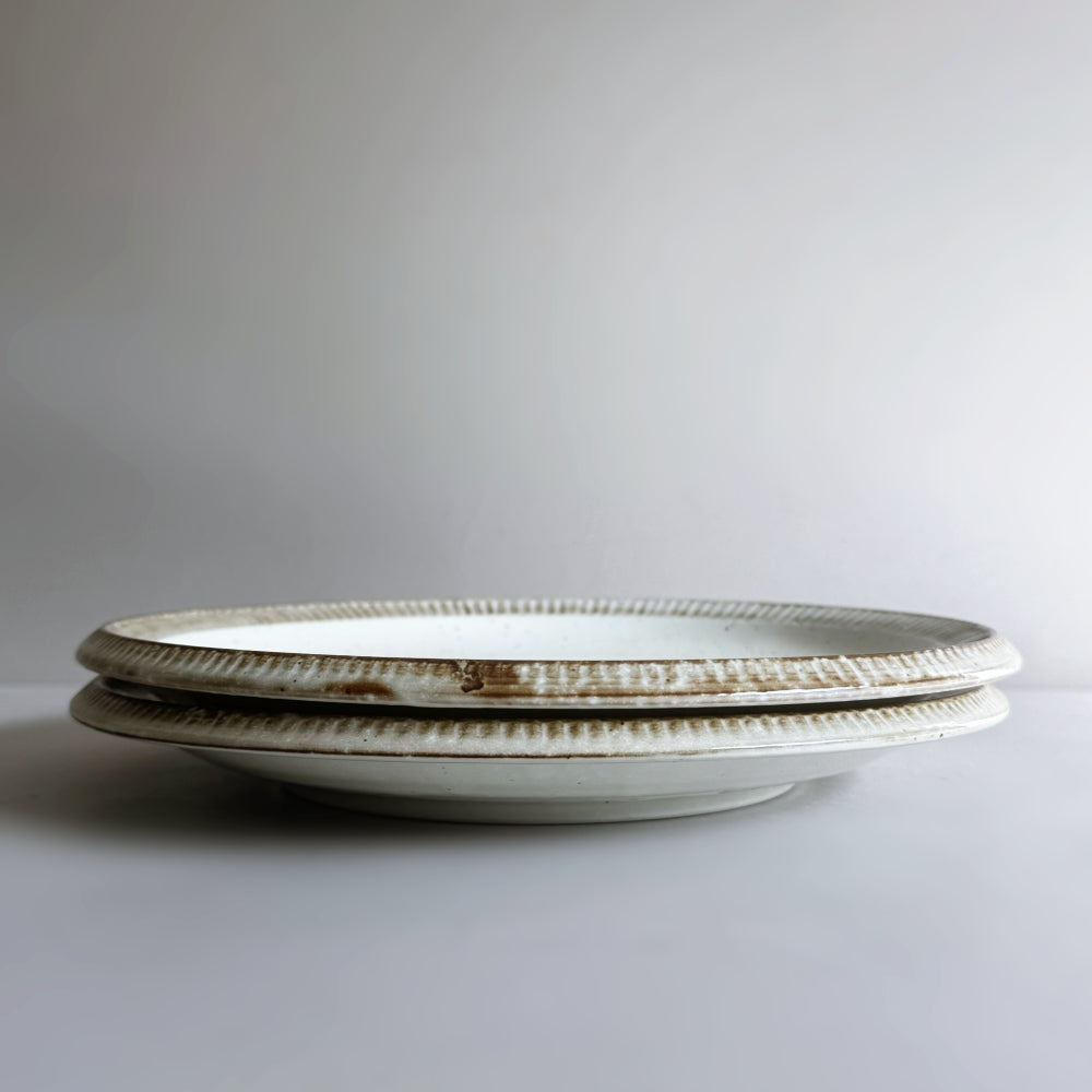 Raised rim dinner plate in cream white glaze. Fuchisabi Kohiki Plate made in Gifu prefecture, Japan. Mino Ware. Available at Toka Ceramics.