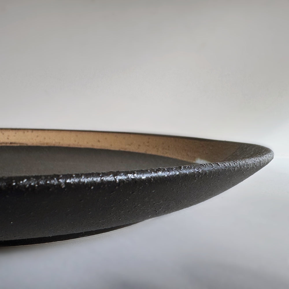 Hakeme dinner plate in black glaze. Mino ware, made in Japan. Available at Toka Ceramics.