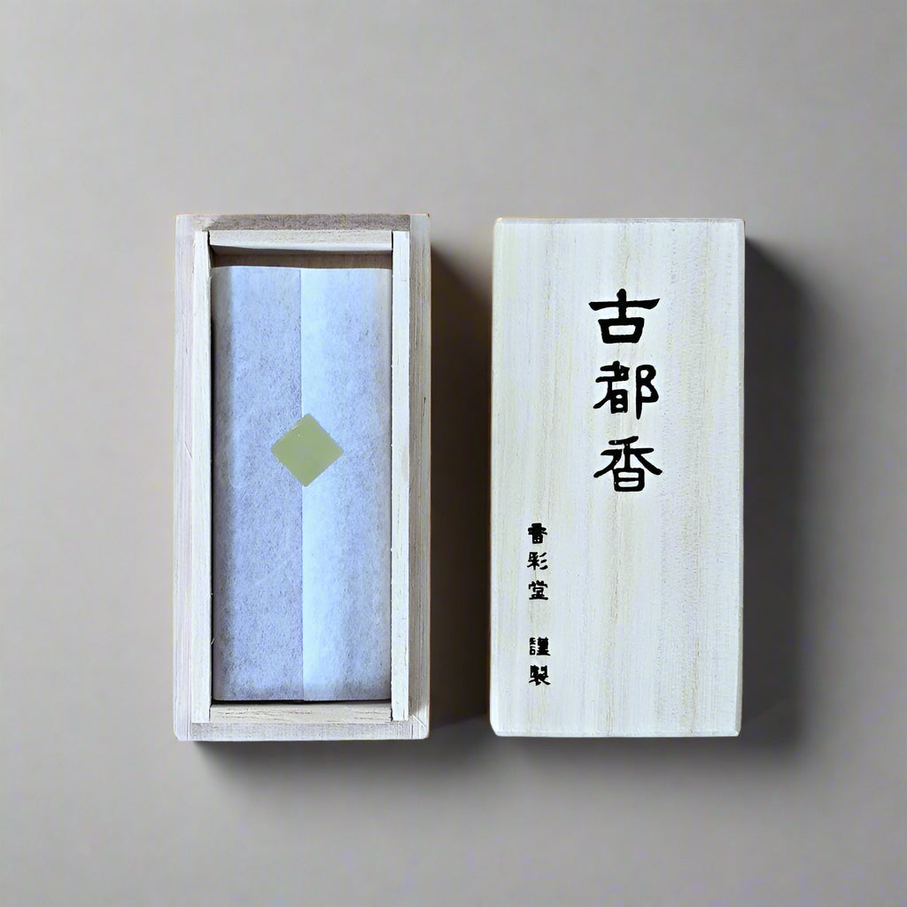 Top-down view of Kousaido Kotokou incense in an open paulownia wooden box with calligraphy lid, from Senju Living.