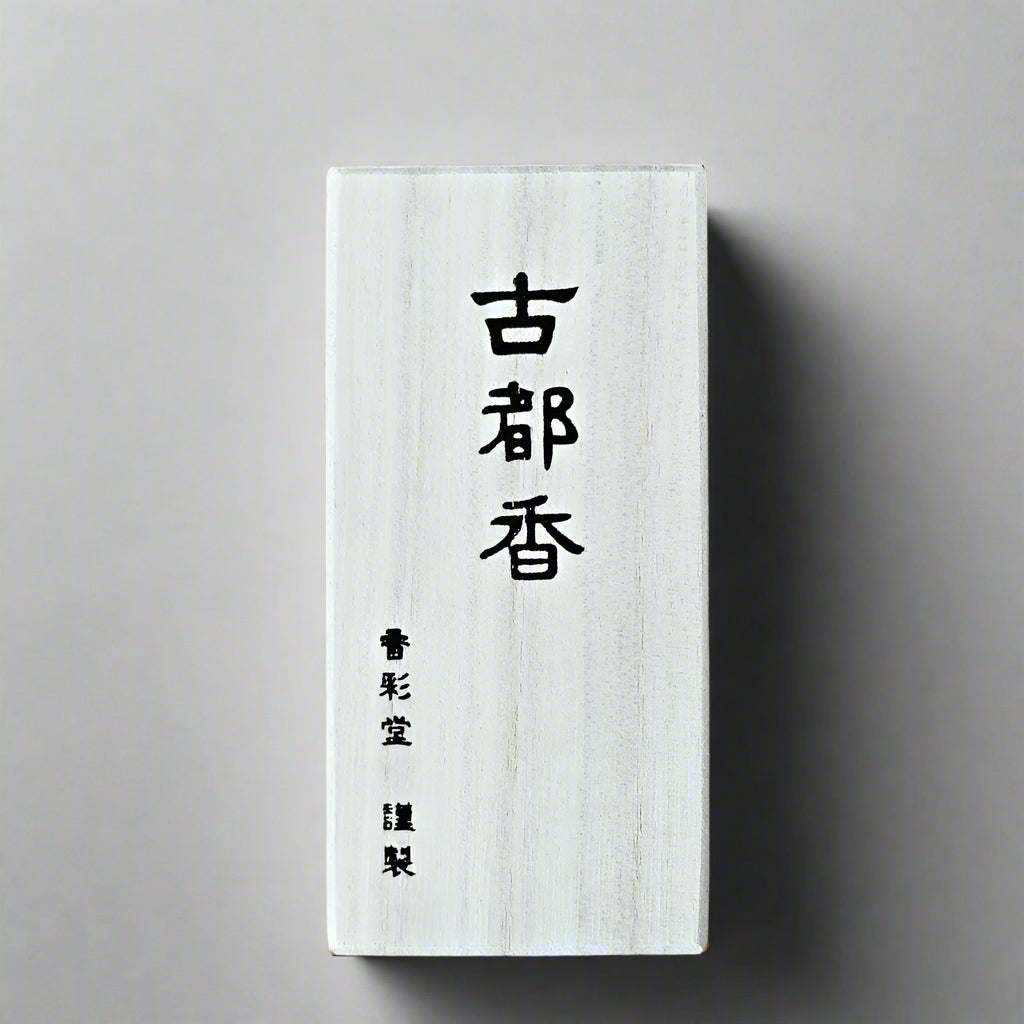 Close-up view of short Kotokou Ancient Town Japanese incense sticks resting next to the minimalist timber packaging.