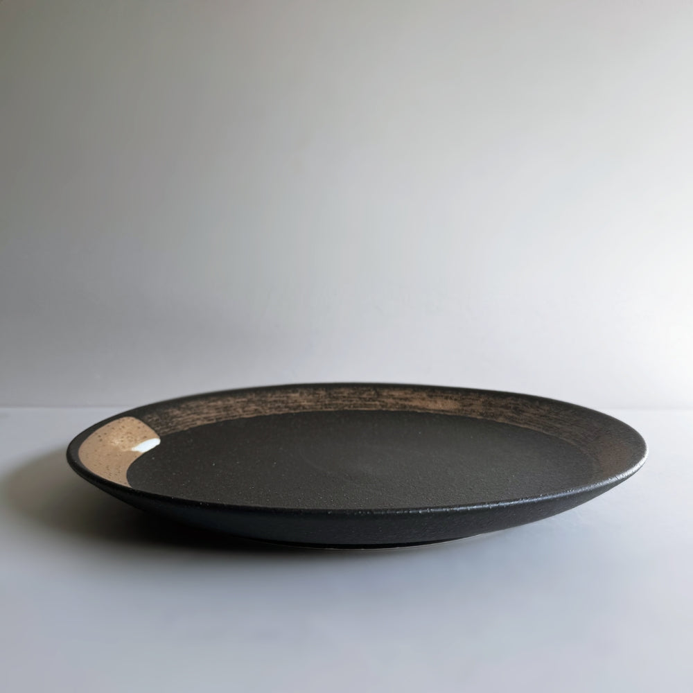 Hakeme dinner plate in black glaze. Mino ware, made in Japan. Available at Toka Ceramics.