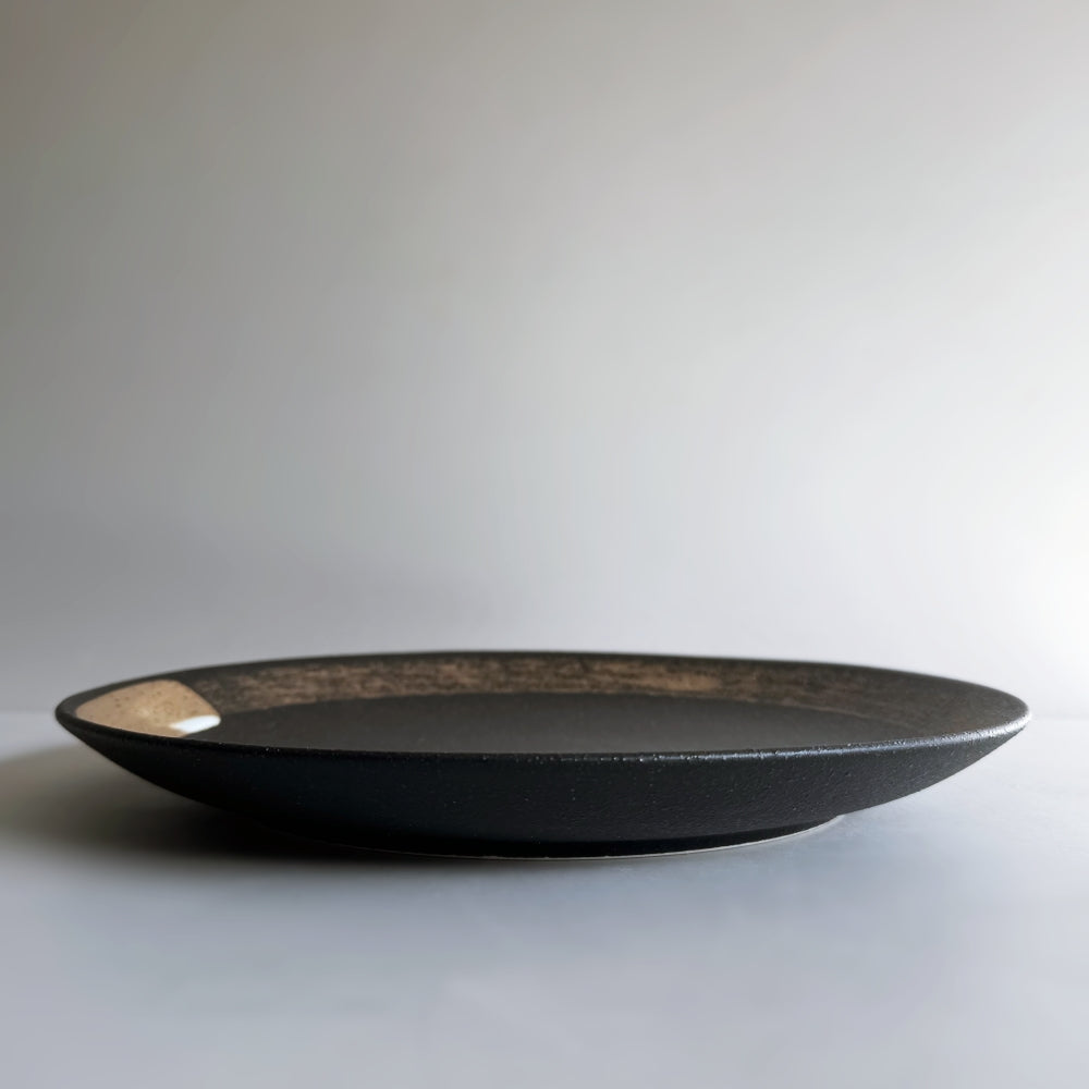 Hakeme dinner plate in black glaze. Mino ware, made in Japan. Available at Toka Ceramics.