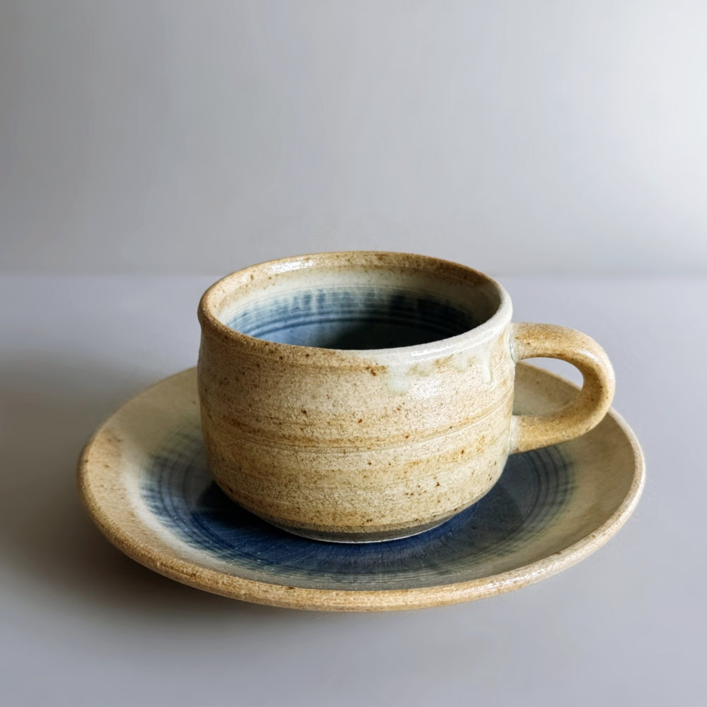 Sandy colour, blue glass glazed cup and saucer set. Handcrafted Japanese pottery, made in Japan. Available at Toka Ceramics.