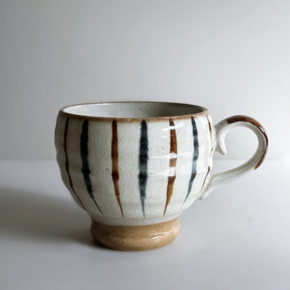 Japanese pottery rounded mug with foot ring with navy and brown tokusa pattern.  Mino ware, made in Japan. Available at Toka ceramics.