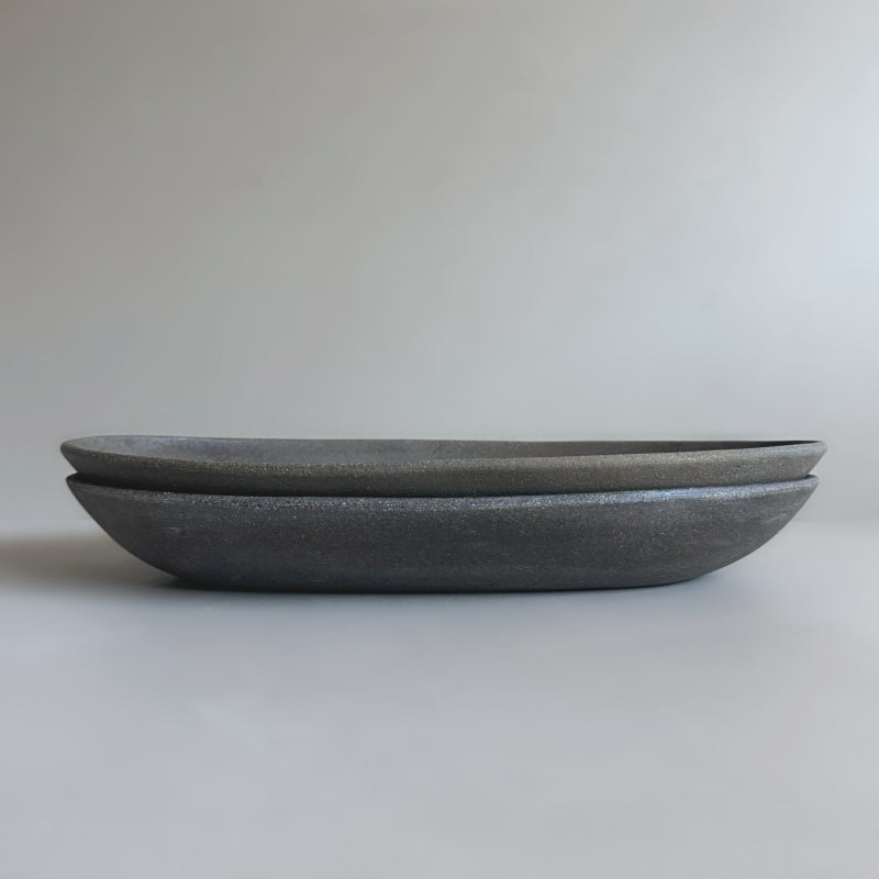 handcrafted Tsugaru Sueki Oval Shallow Bowls made in Japan, featuring a minimalist design with smooth, unglazed dark surfaces.