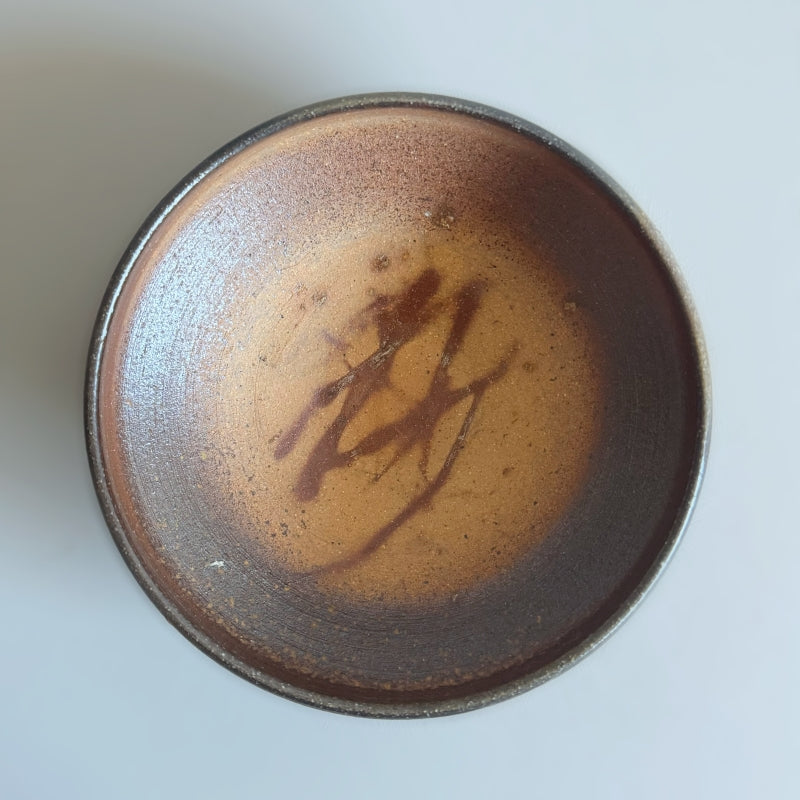 An earthy brown medium sized bowl without glaze. Handcrafted by Tsugaru Kanayama Pottery in Japan. Available at Toka Ceramics.