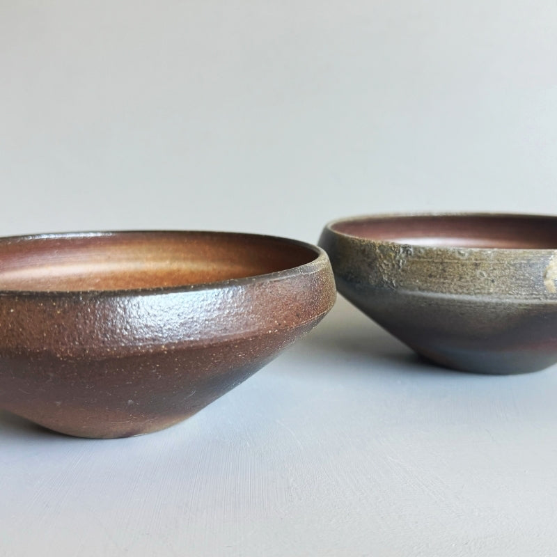 An earthy brown medium sized bowl without glaze. Handcrafted by Tsugaru Kanayama Pottery in Japan. Available at Toka Ceramics.