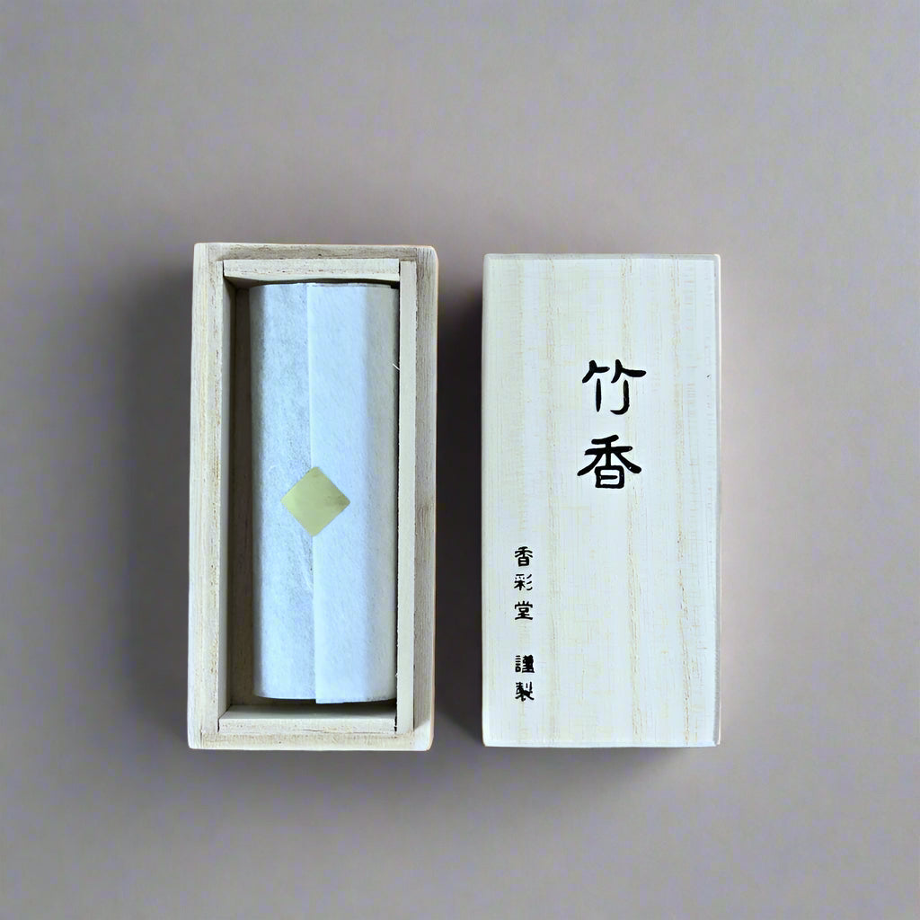 Top-down view of Takekou incense in open paulownia box wrapped in traditional paper with calligraphy lid, from Senju Living.